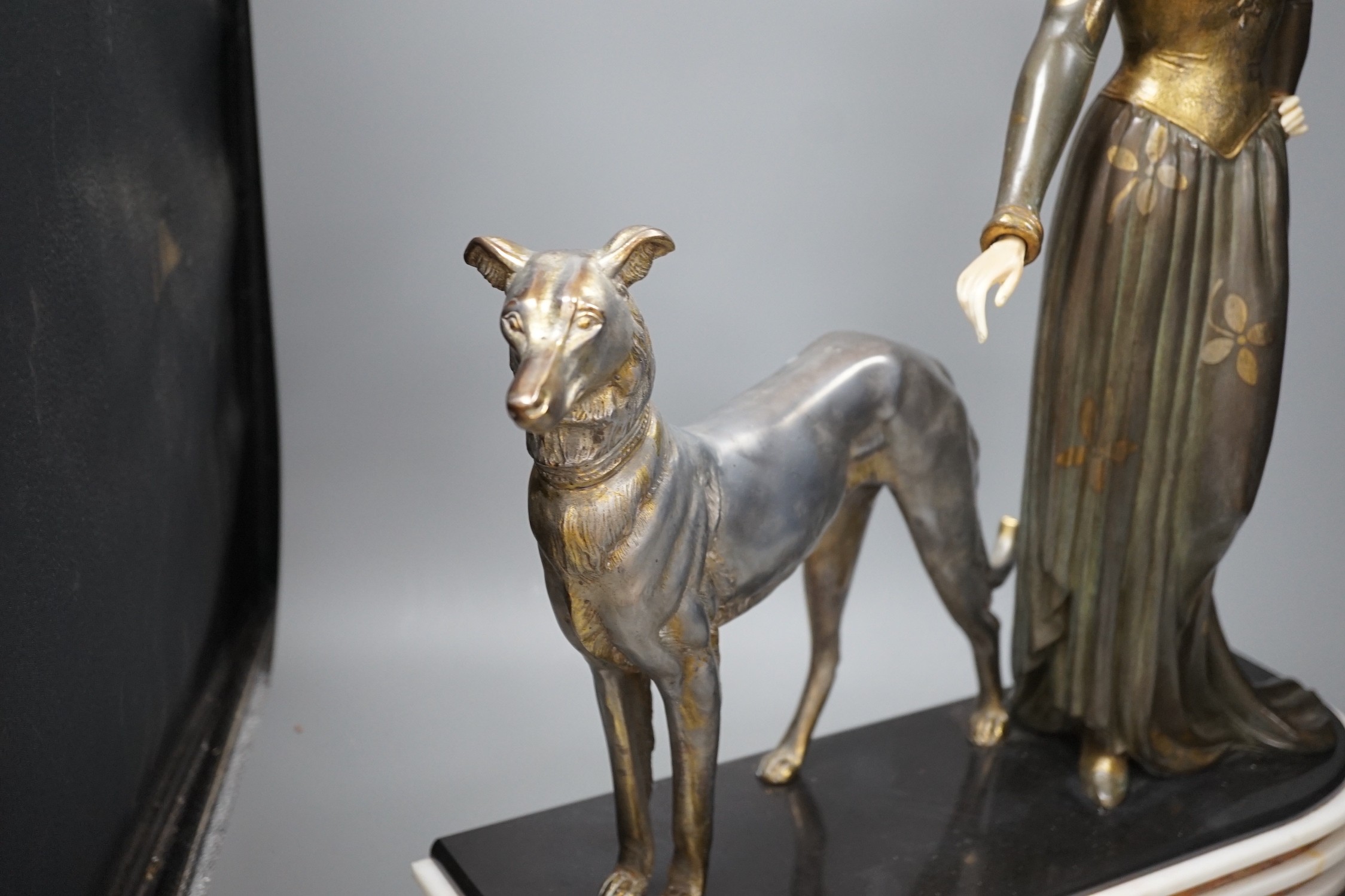 An Art Deco spelter and composition figure of a lady and a hound, signed Menneville, 57 cms high